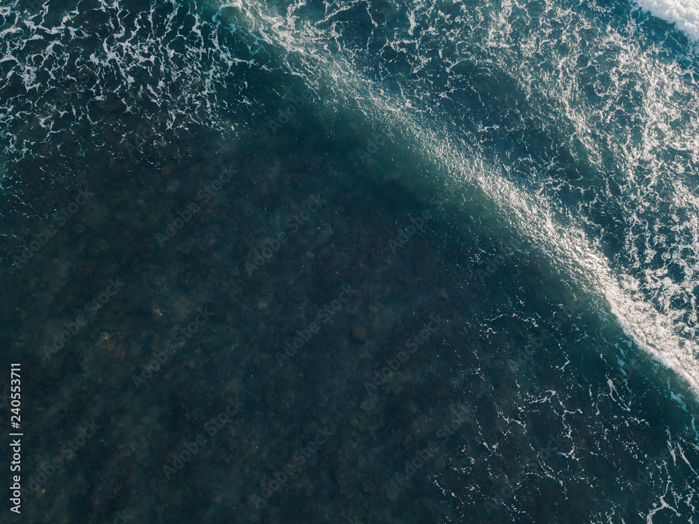 Aerial view beautiful of sea waves from drone. Stock image of blue color of ocean water, sea surface. Top view on turquoise waves, clear water surface texture.  Top view, amazing nature background