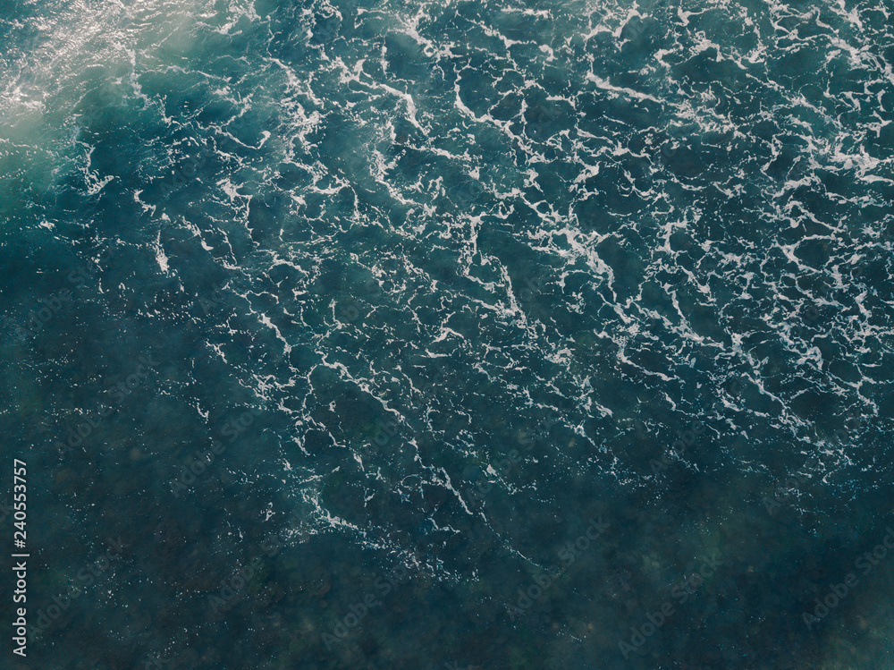 Fototapeta premium Aerial view beautiful of sea waves from drone. Stock image picture of blue color ocean water, wave, sea surface. Top view on turquoise waves, clear water surface texture. Top view, amazing nature