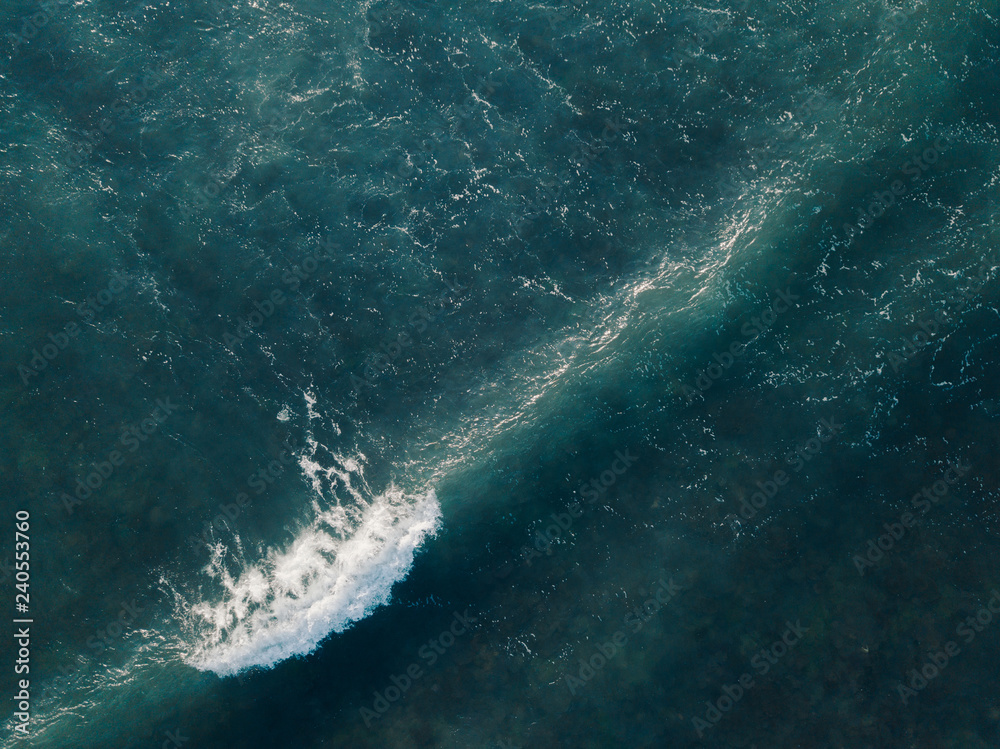 Aerial view beautiful of sea waves from drone. Stock image of blue color of ocean water, sea surface. Top view on turquoise waves, clear water surface texture.  Top view, amazing nature background