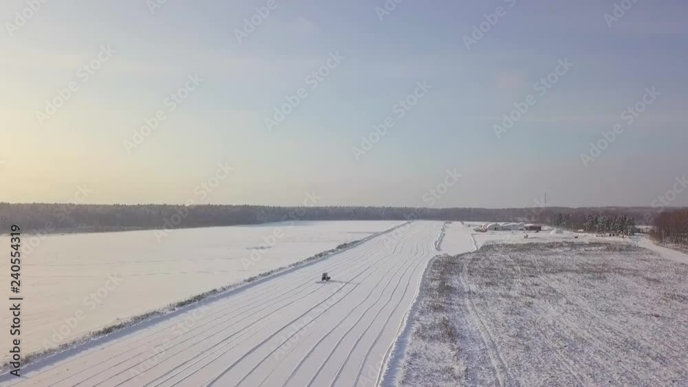 Aerial view of a tractor removing snow from a takeoff runway Aerial view of a tractor removing snow from a takeoff runway
