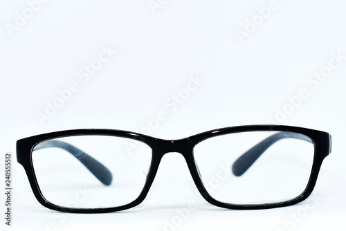 Eye glasses with black frames are arranged on a white background.