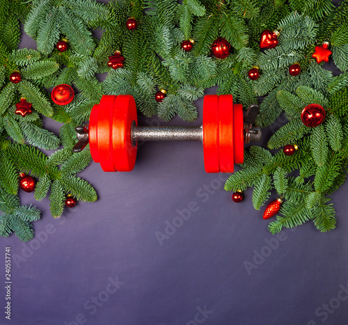 Christmas or New Year on a white background. Composition with dumbbells, gift, red and gold glass balls, fir tree branches for healthy lifestyle and sport