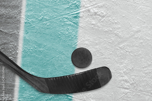 Hockey stick, puck and ice arena fragment with black and blue-green lines