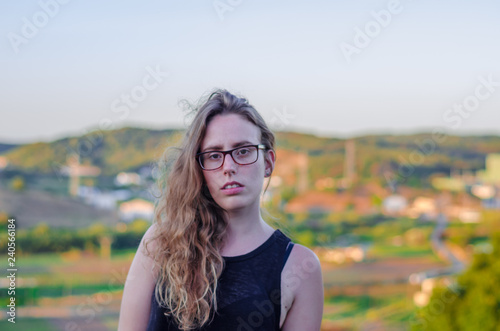 Photograph of a girl with flares on a hill in Menorca with a beautiful sunset in the background.