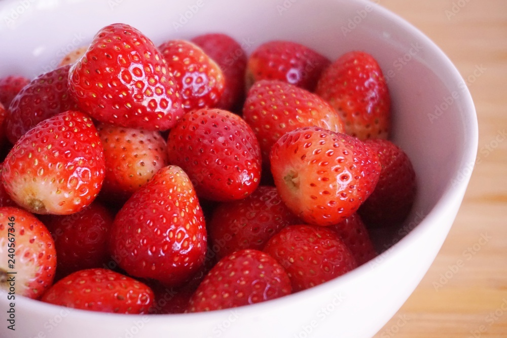 Strawberries in white ceramic bowl. Fresh nice strawberries on wooden table. Strawberries in white ceramic bowl. Fresh nice strawberries on wooden table.