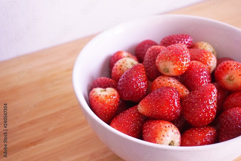 Strawberries in white ceramic bowl. Fresh nice strawberries on wooden table. Strawberries in white ceramic bowl. Fresh nice strawberries on wooden table.
