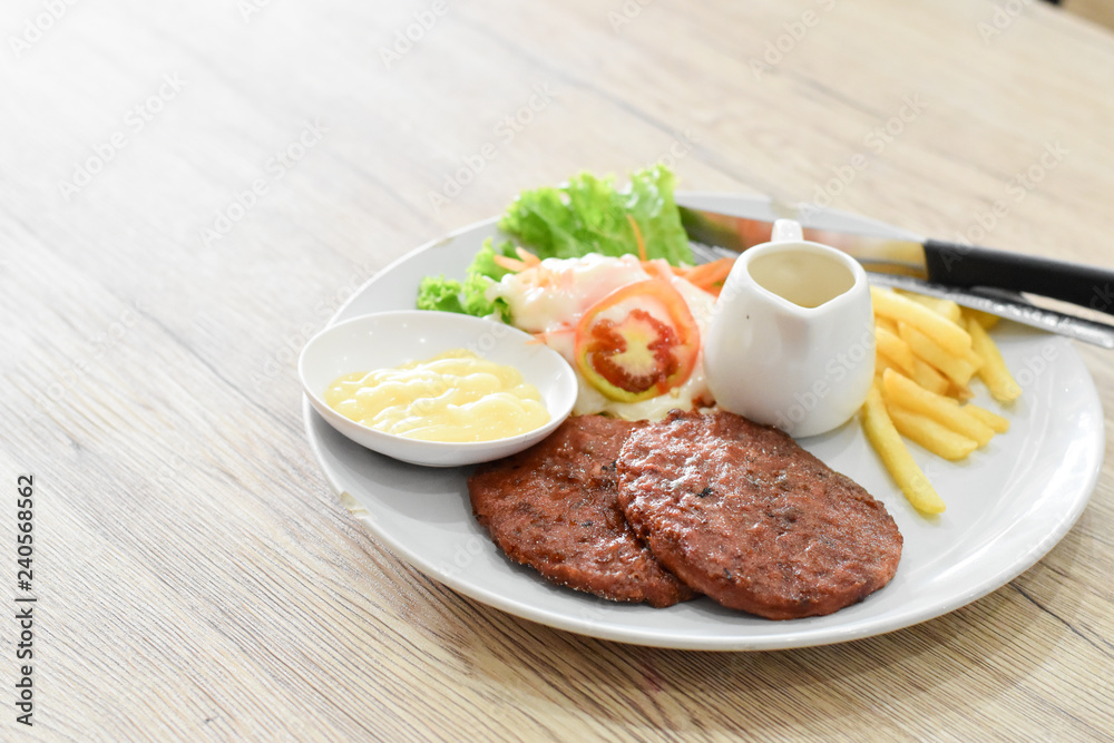 Beef steak, salad and french fries on a vintage wood background Beef steak, salad and french fries on a vintage wood background