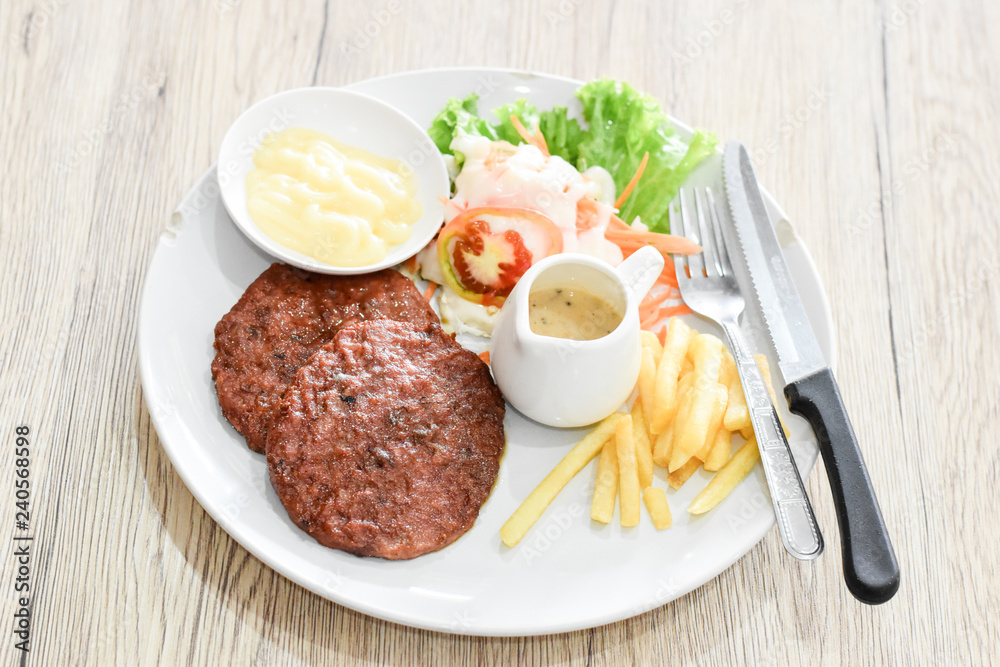 Beef steak, salad and french fries on a vintage wood background Beef steak, salad and french fries on a vintage wood background