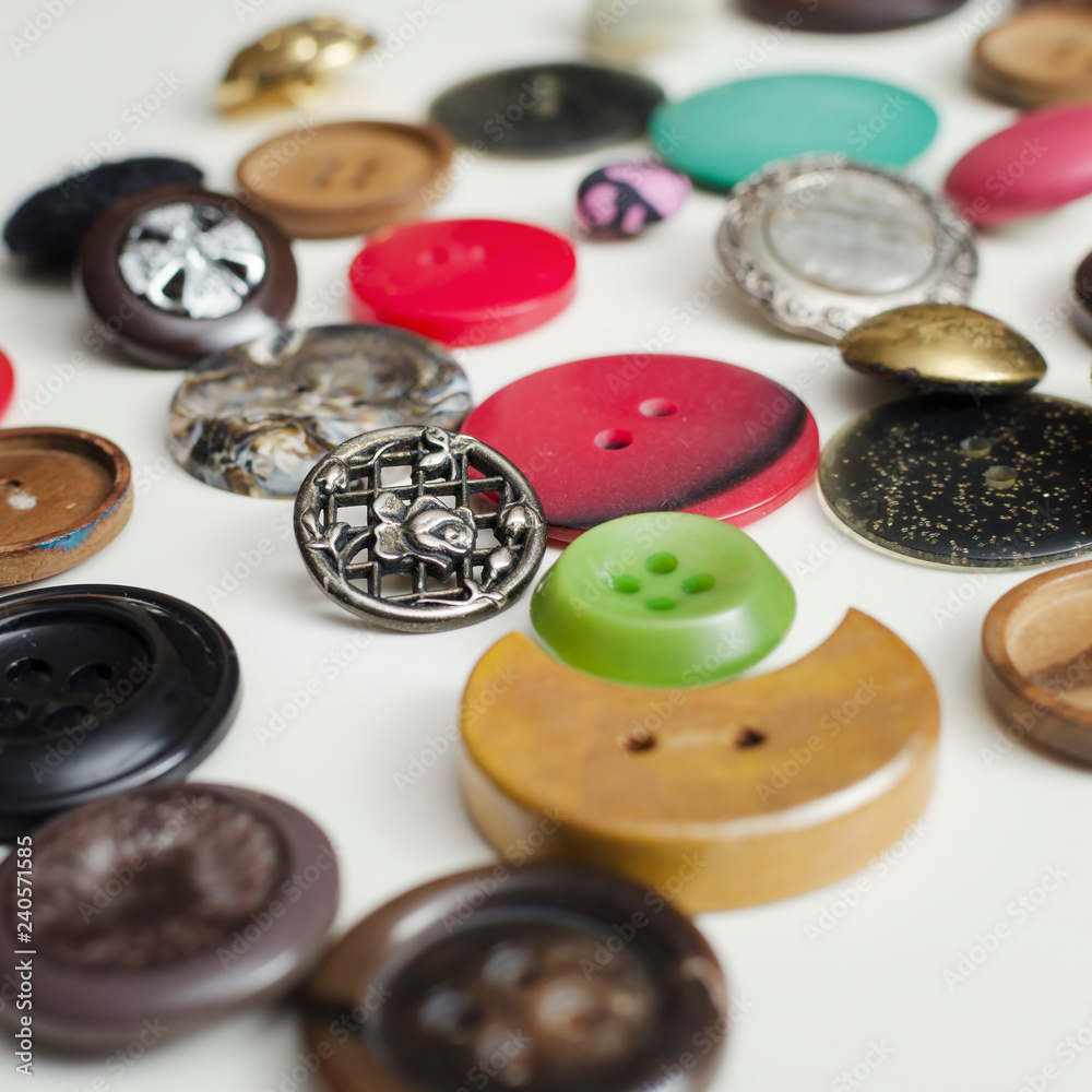 Lot Of Colorful Buttons on White Wooden Table Lot Of Colorful Buttons on White Wooden Table