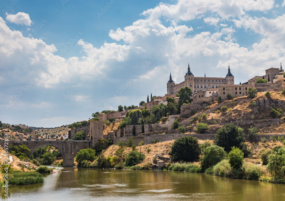 View of the old city and the Alcantara Bridge leading to the Gate of the Sun from the side of the River Tajo Toledo, Spain.