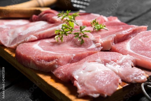close up scene of pork steak meat with parsley. raw meat steaks