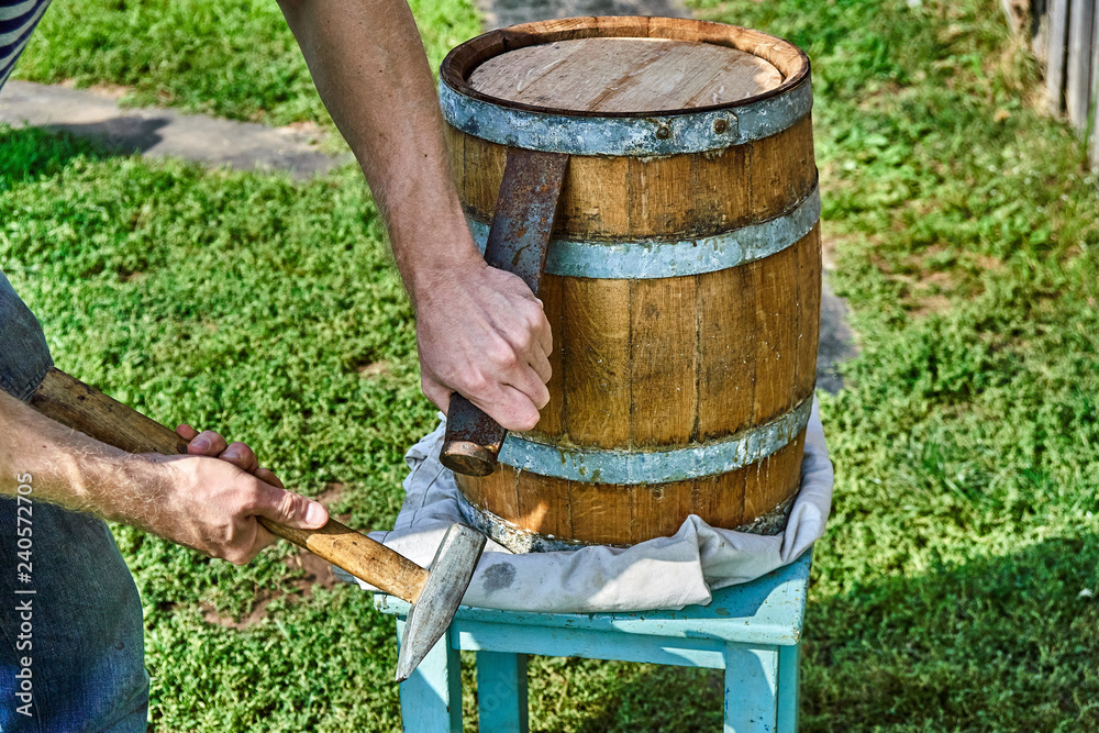 Fototapeta premium Oak Barrel. Opening the barrel with a chisel and hammer