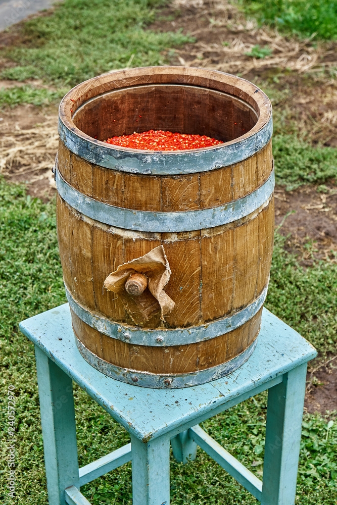 Oak Barrel. Open wooden barrel filled with milled hot pepper. Hot sauce production Oak Barrel. Open wooden barrel filled with milled hot pepper. Hot sauce production