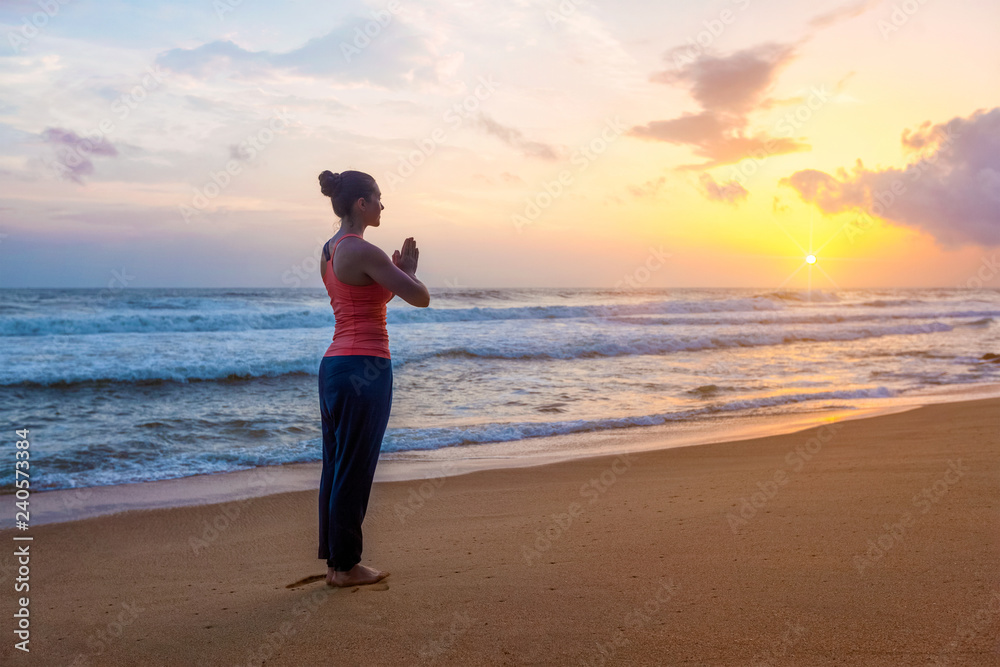 Woman doing yoga on beach