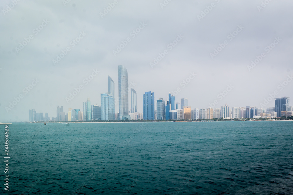 Obraz premium Beautiful shot of Abu Dhabi city skyline towers and beach on a cloudy day