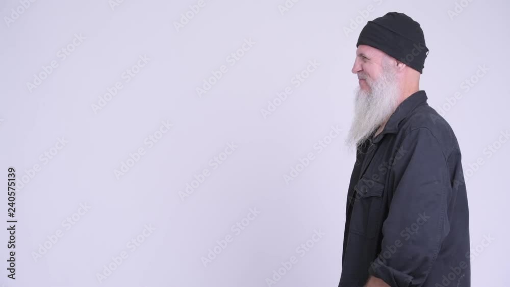 Profile view of happy mature bearded hipster man smiling Profile view of happy mature bearded hipster man smiling