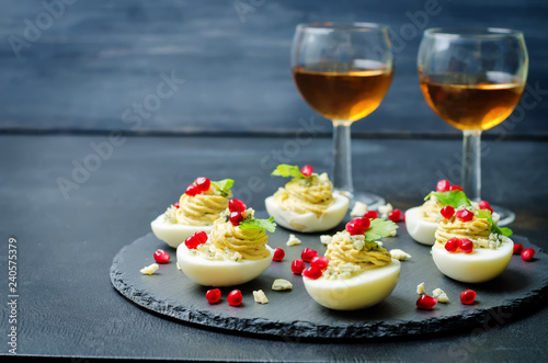 Blue cheese deviled eggs with pomegranate and fresh parsley leaves