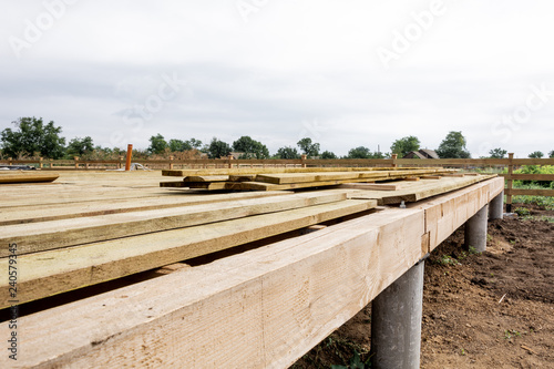 Wooden frame house foundation on screw piles, construction site