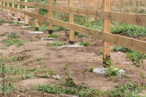 The base of the wooden fence. Fence ranch style details.