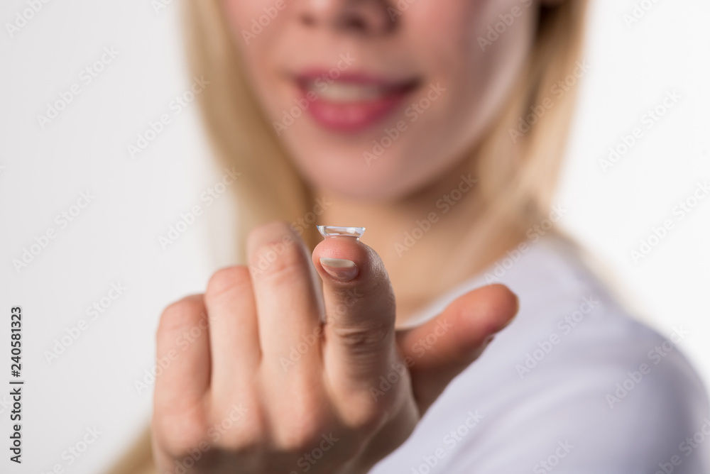Soft contact lens on the finger of the female hand on a white background Soft contact lens on the finger of the female hand on a white background