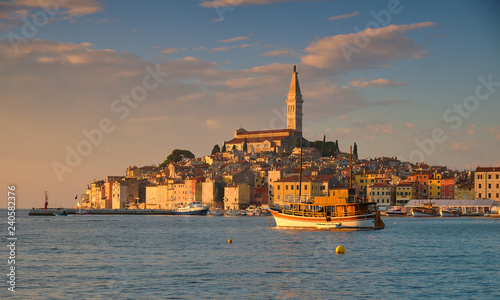 View of the city of Rovinj in Croatia. Sunset shot of the old town from harbour, showing boats basking in golden light