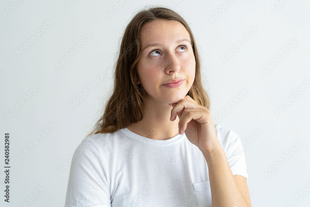 Pensive young woman looking upwards. Pretty lady touching chin. Contemplation concept. Isolated front view on white background.