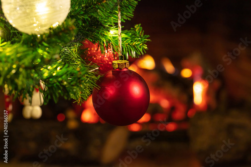 Christmas tree close up on blurred burning fireplace background