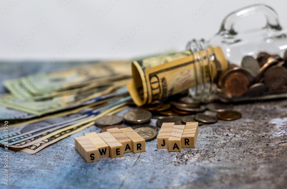 Swear Jar challenge concept with glass jar filled with coins, simple background Swear Jar challenge concept with glass jar filled with coins, simple background