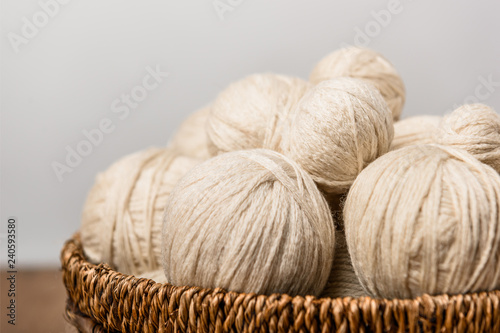 close up view of yarn balls in wicker basket on grey background