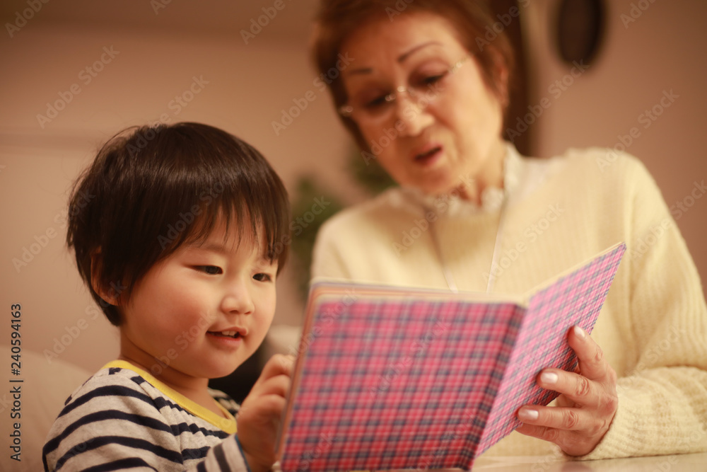 絵本を読む男の子とシニア女性 絵本を読む男の子とシニア女性