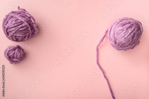 top view of purple knitting balls on pink tabletop