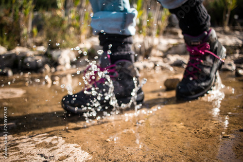 Trekking in the mountains. Detail of a waterproof shoe in contact with water on a walk in the mountains.