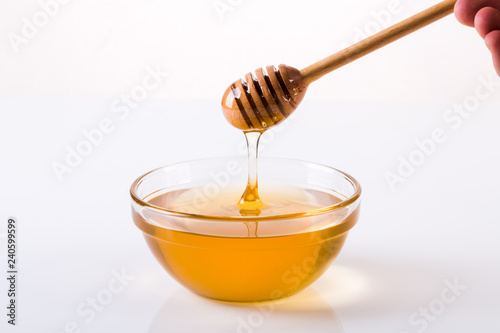Honey bowl with dipper and flowing honey