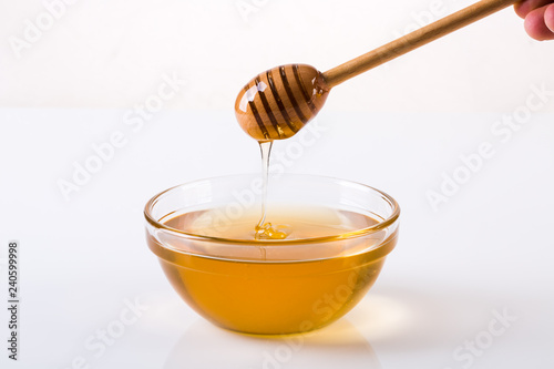 Honey bowl with dipper and flowing honey