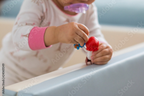 A baby's hand holding a toy 