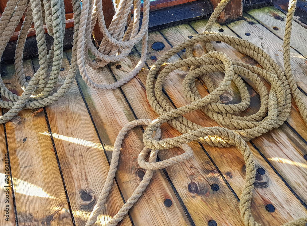 Thick old ropes on the wooden deck of the ship