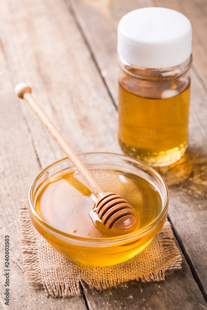Honey in glass bowl on wooden table Honey in glass bowl on wooden table