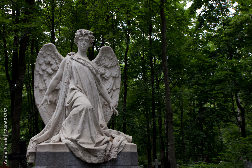grieving angel against a background of dark green foliage