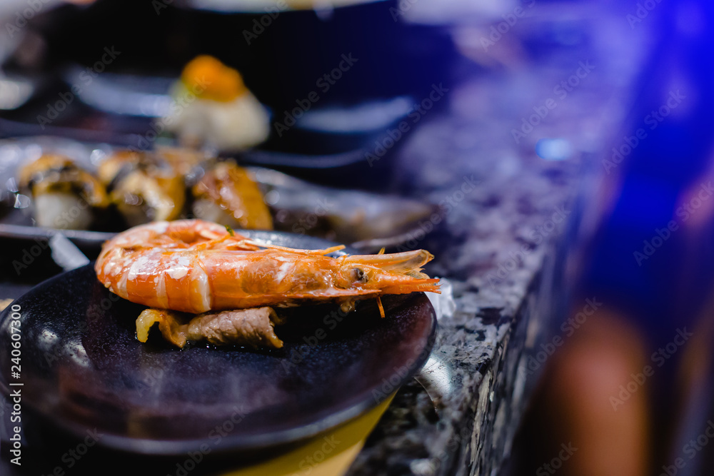 Selective focus to grilling shrimp on black plate Selective focus to grilling shrimp on black plate