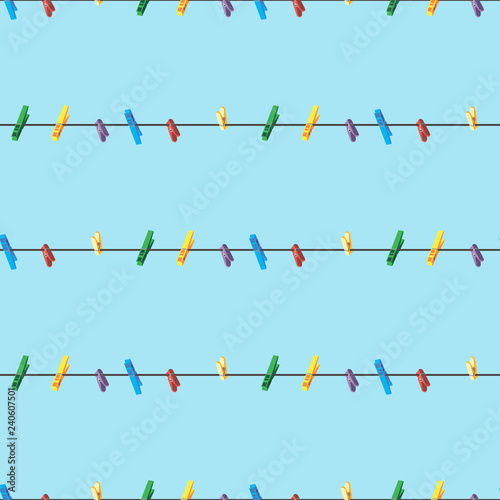Seamless pattern Colored clothes pins on a clothes line rope on blue background .