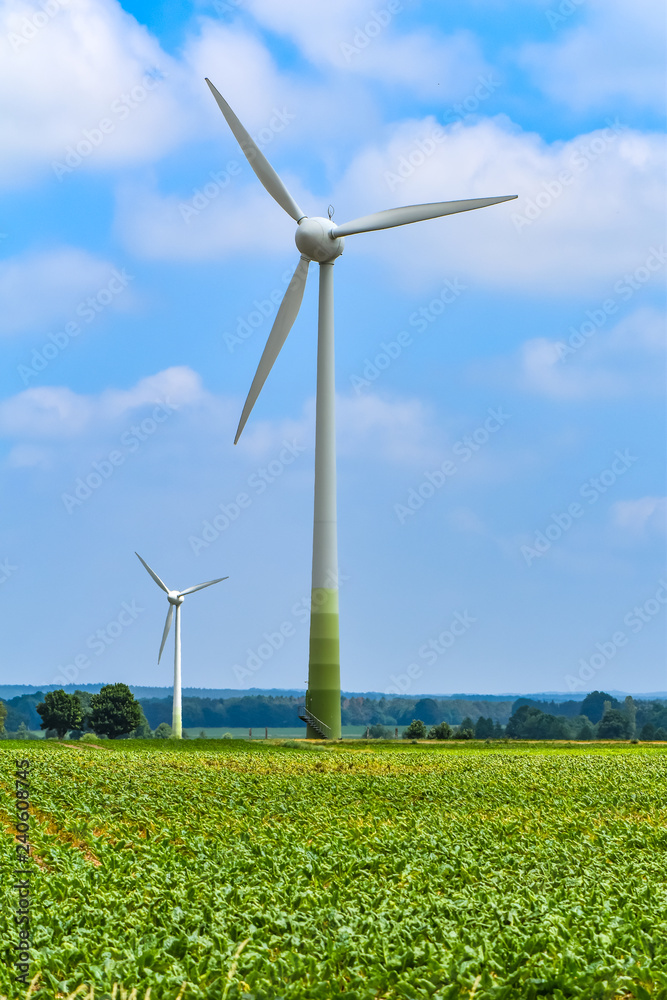 Two wind turbines for environmentally friendly energy production on a field in Germany.