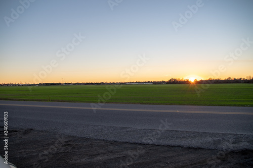 Evening sun setting behind sugar cane fields in New Roads, Louisiana.  © Trevor