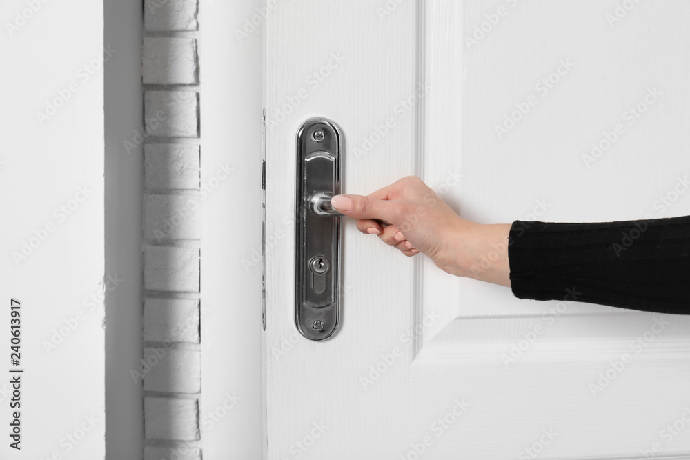 Woman opening white wooden door, closeup view Woman opening white wooden door, closeup view
