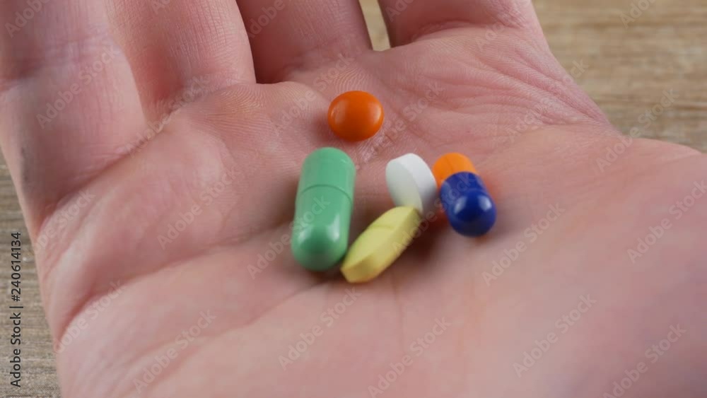 multiple colors pills in hand , Taking Your Medication. multiple colors pills in hand , Taking Your Medication.