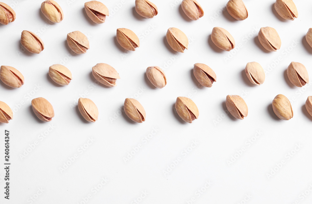 Organic pistachio nuts on white background, flat lay. Space for text