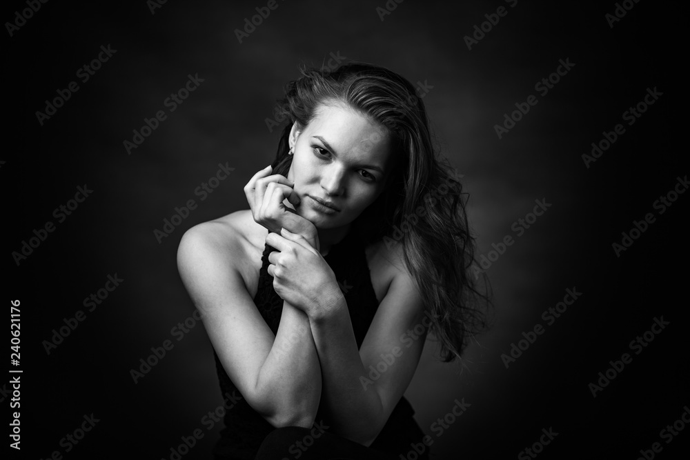 Dramatic black and white portrait of a beautiful girl on a dark background Dramatic black and white portrait of a beautiful girl on a dark background