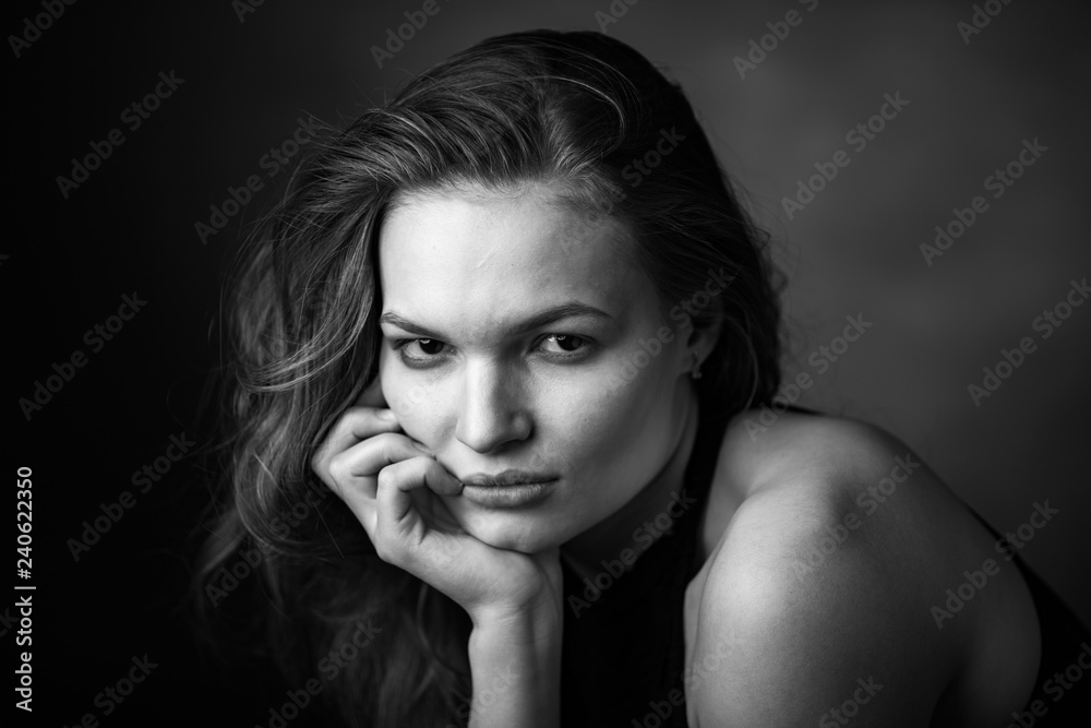 Dramatic black and white portrait of a beautiful girl on a dark background Dramatic black and white portrait of a beautiful girl on a dark background