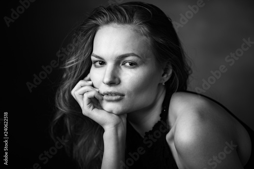 Dramatic black and white portrait of a beautiful girl on a dark background