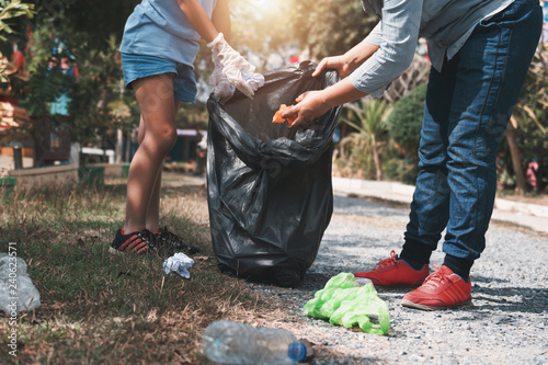 Mother and child help picking up trash at park