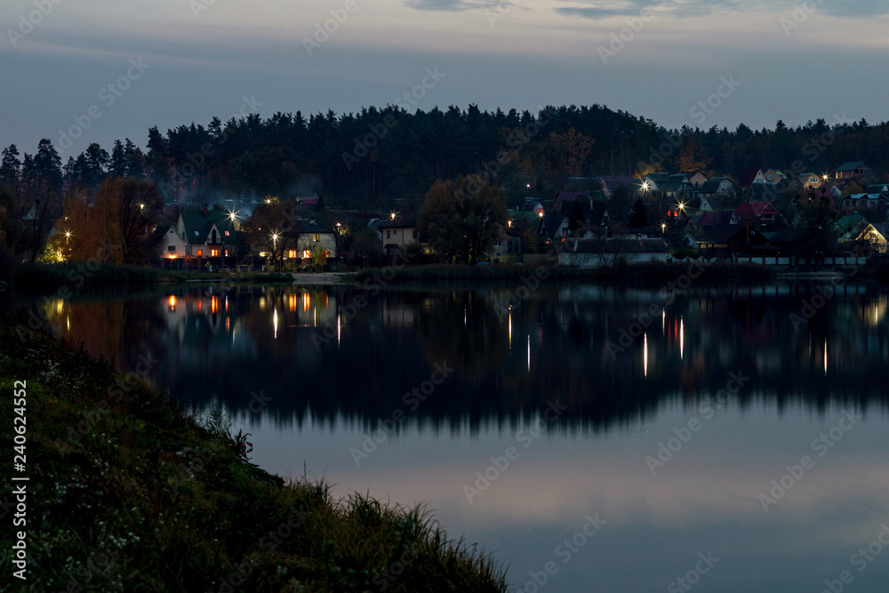 Village on the lake. Evening landscape with a reflection in the water. Selective focus. Village on the lake. Evening landscape with a reflection in the water. Selective focus.